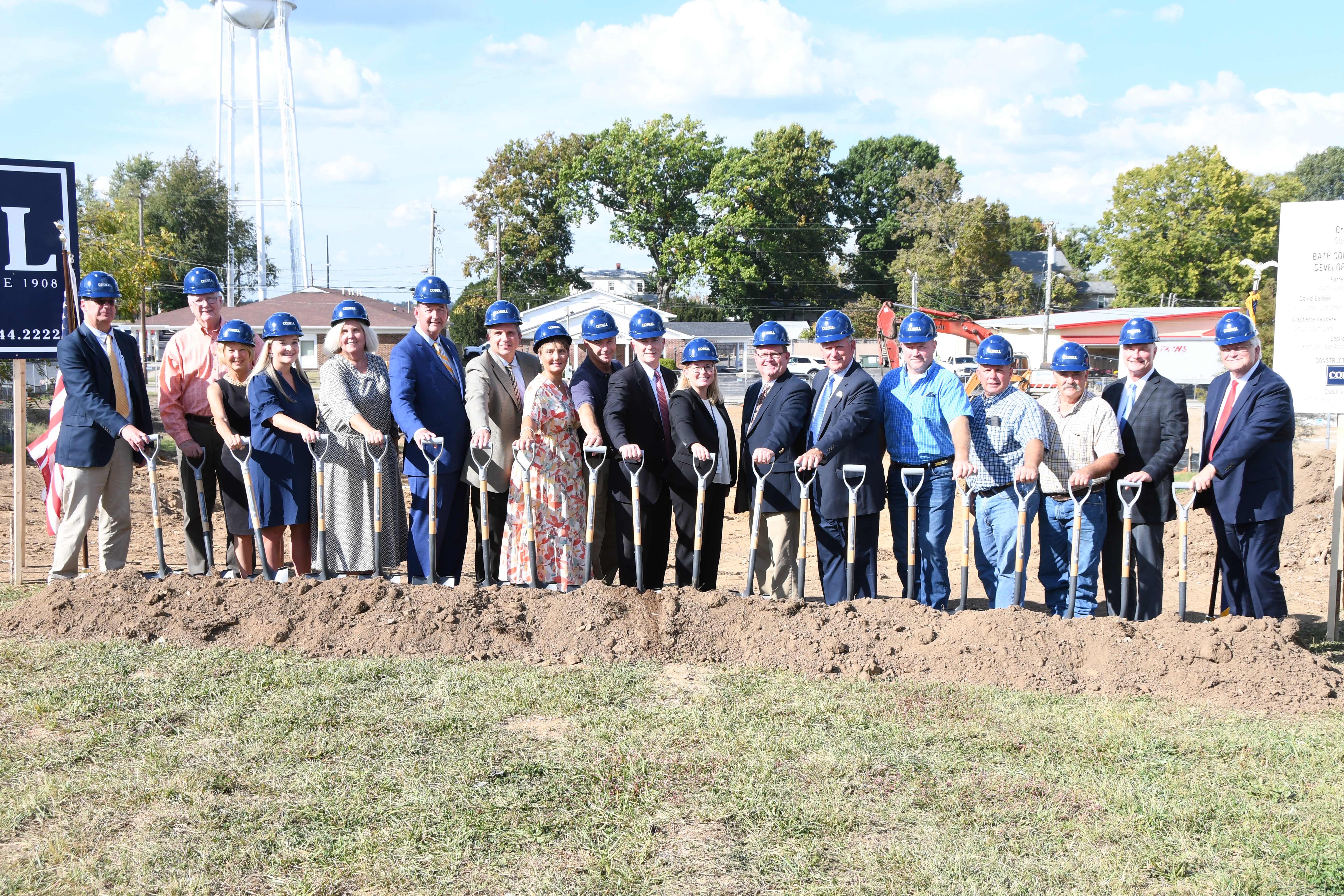 A large line of people with hard hats and shovels.