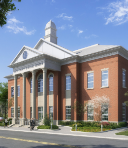 Modern brick and white courthouse with small trees in front. 