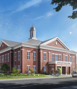 Modern brick and beige courthouse with small bushes in front. 