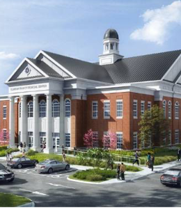 A large red brick building with cars parked in front. 
