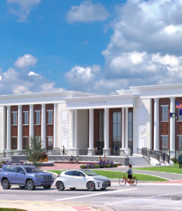 A white column courthouse will a person riding a bike and cars driving by. 