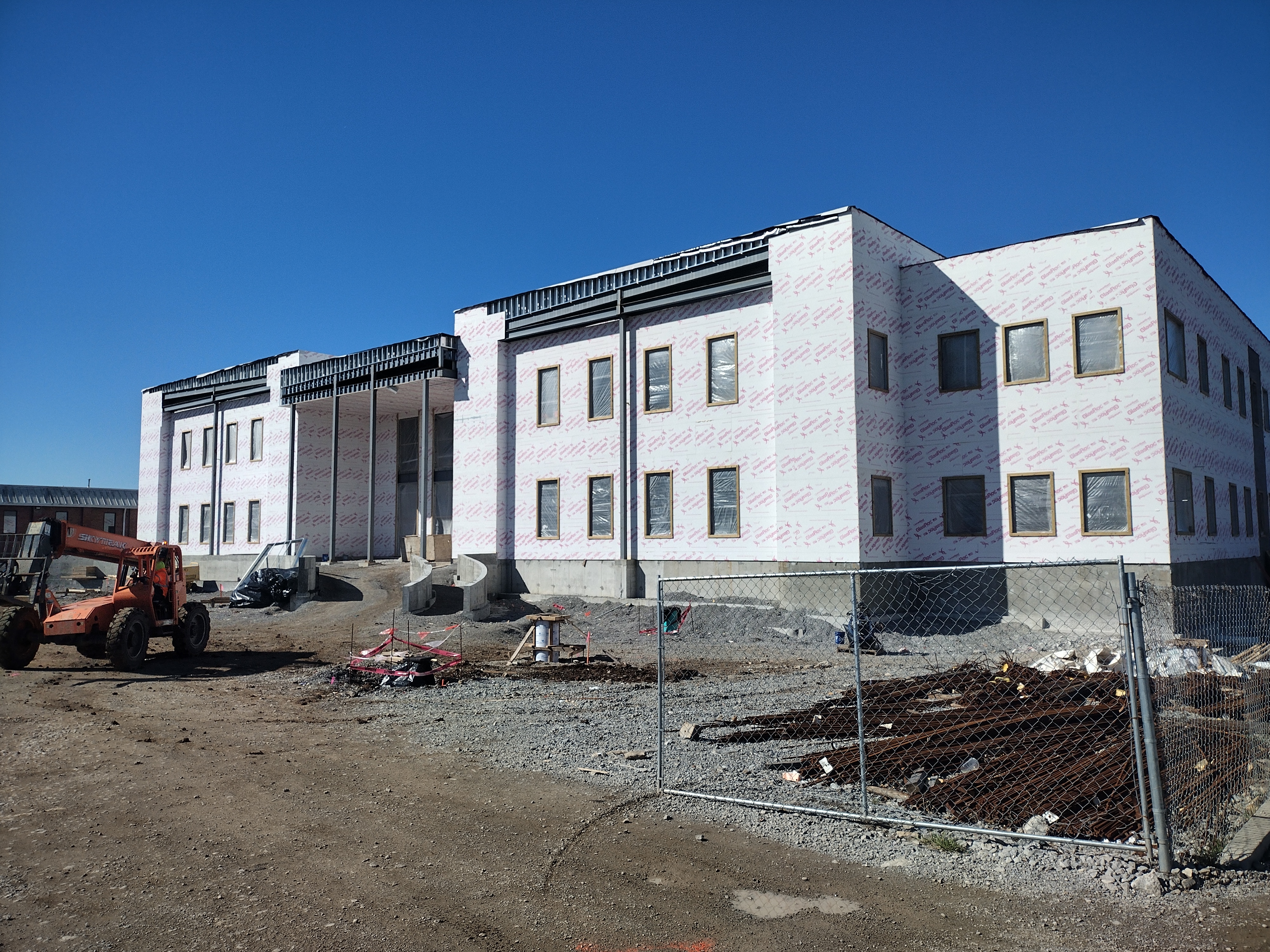 Construction site with walls up, machinery and gates.