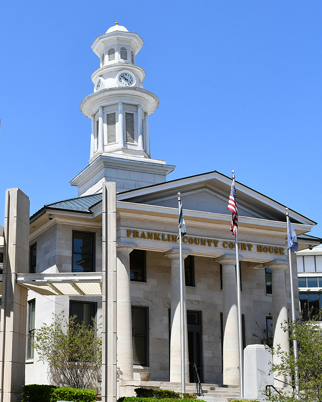 Franklin County Courthouse, a grand stone building featuring wide stairs leading up to the main lobby. A layer of snow in front.