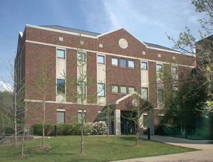 Rockcastle County Courthouse Annex, three story brown brick building. Large green trees surrounding main enterance and sidewalks