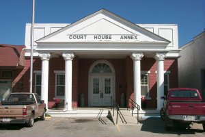 Spencer County Courthouse Annex, a brick and white building with cars in the front parking lot. 