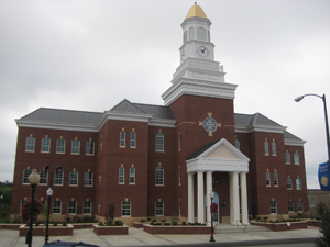 Taylor County Judicial Center, red brick courthouse with white columns at the entrance. Symmetrical design with large windows.