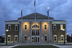 A view of the Todd County Court of Justice at dusk, showcasing its glass windows reflecting the evening light. 